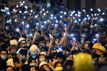 Protesters hold up their mobile phones as they gather outside the police headquarters in Hong Kong on June 21. (Hector Retamal/AFP/Getty Images)